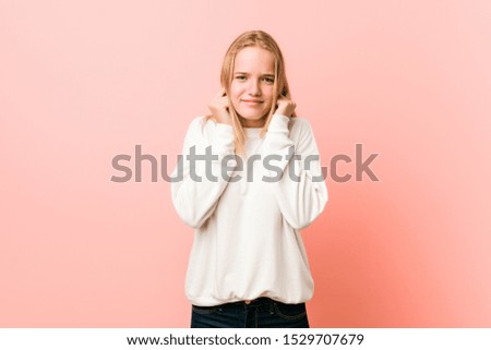 Young blonde teenager woman covering ears with hands.