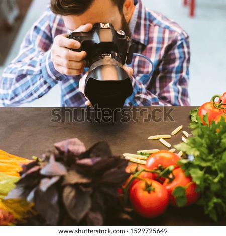 Food photography. Vegetarian lifestyle blog. Male stylist taking picture of organic ingredients.