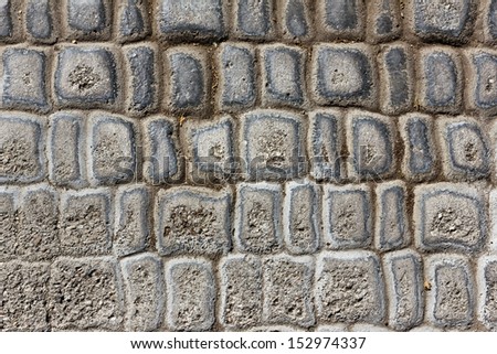Parts of this cobbled street are different from top to bottom. The bottom part is rough and dry. Compare to the top, the stone is more round with dirt between them. 