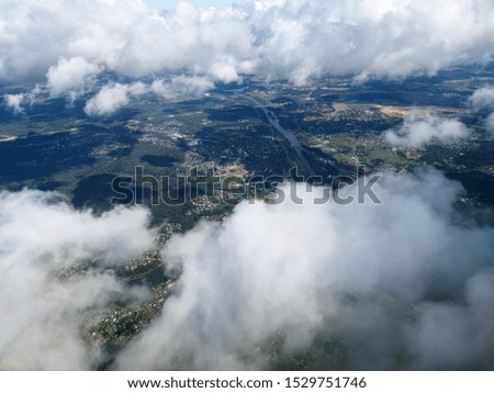 Clouds above the ground view from an airplane as a background.