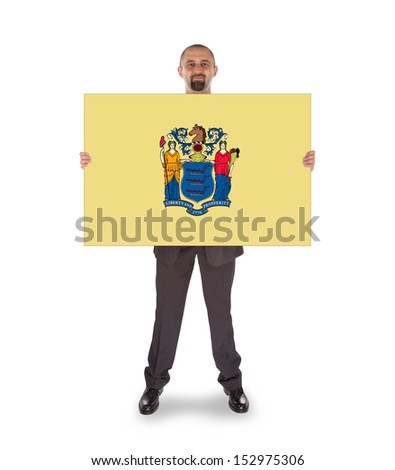 Smiling businessman holding a big card, flag of New Jersey, isolated on white