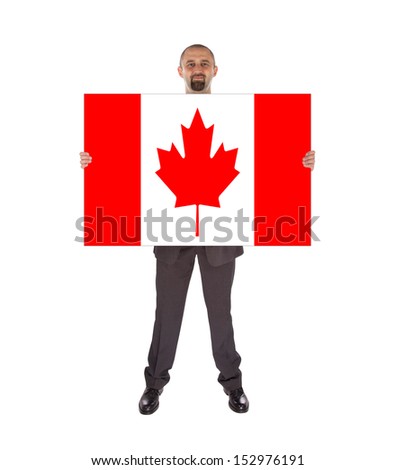 Smiling businessman holding a big card, flag of Canada, isolated on white