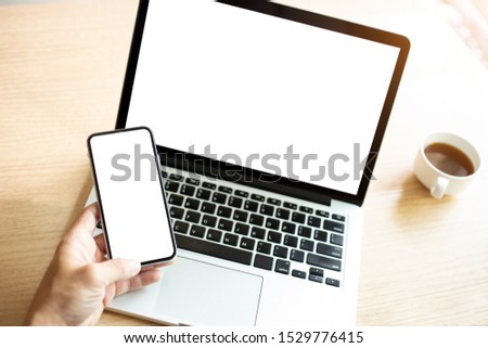 mockup image blank screen computer,cell phone with white background for advertising text,hand man using laptop texting mobile contact business search information on desk in office.marketing concept
