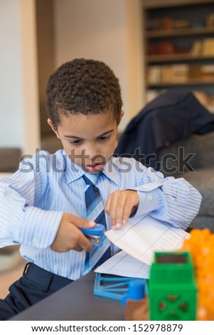 A little boy is holds the stapler paper in the business center
