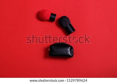 Makeup brushes on red background. Kabuki brushes for applying powder.