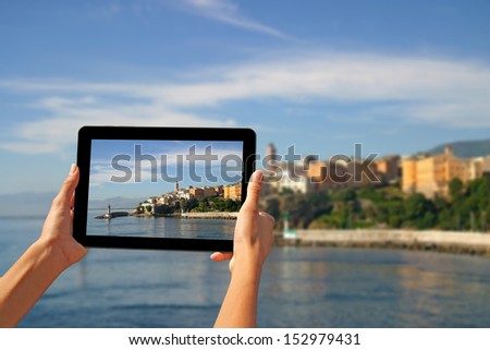 Girl taking pictures on a tablet in Bastia, Corsica, France.