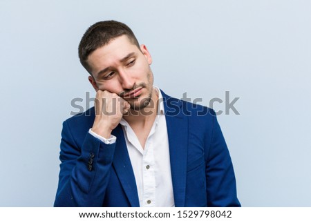 Young business caucasian man who feels sad and pensive, looking at copy space.
