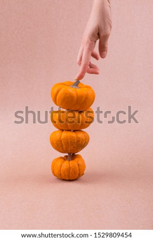 Four mini pumpkins for Halloween with hand. Decor.