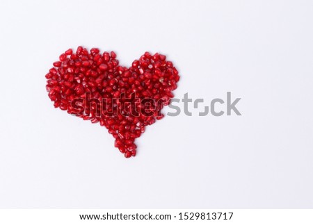 Pomegranate isolated. Pomegranate seeds on white background. Heart shape.