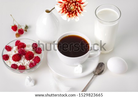 Breakfast with cottage cheese and raspberries on a light background.