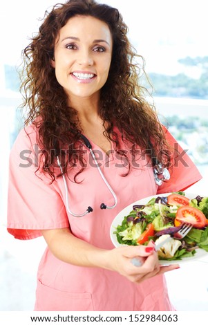 Happy nurse holding a fresh salad