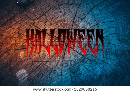 Halloween, red lettering, on wood texture background, in blue and orange tones
