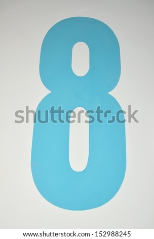 Number eight painted in blue on a wall