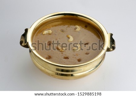 Payasam - pradaman isolated image  of south indian special sweet dish beautifully arranged in a traditional style ,a brass vessel which is  garnished with cashewnut and kismiss with white background