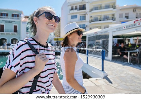 Walking happy mother parent and teenage daughter summer holidays together in resort sea town