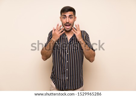 Handsome man with beard over isolated background with surprise facial expression