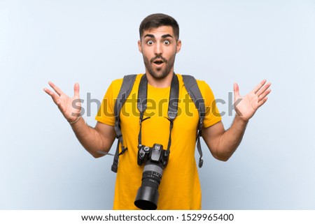 Young photographer man with surprise facial expression