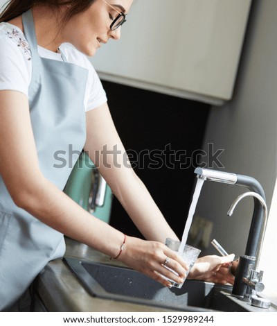 Woman hand's filling the glass of water