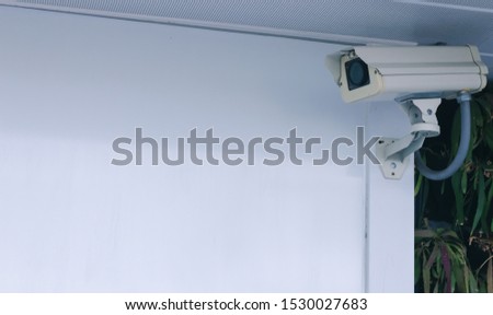 Modern security CCTV camera on wall. Life safety precaution monitor system and prevent crime for home, business office, or building.