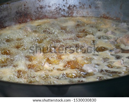 Chicken meat is being deep fried in wok
