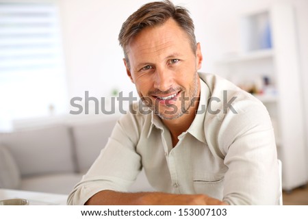 Attractive smiling man relaxing at home Royalty-Free Stock Photo #153007103
