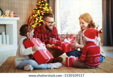 happy family parents and children open presents on Christmas morning
