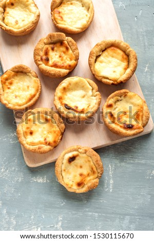 Pastel de Nata Portugese egg custard pies on blue background, top view, flat lay.
