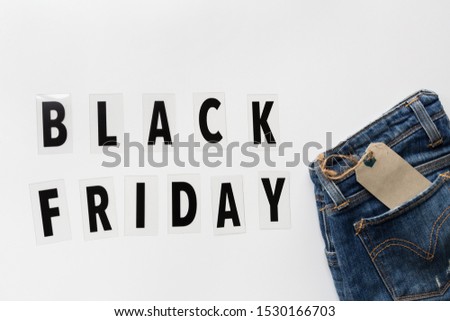 Creative promotion composition Black friday text and jeans on white background. Flat lay, top view, overhead, mockup, template. Minimal abstract background. Online shopping, sale, promo. Web banner