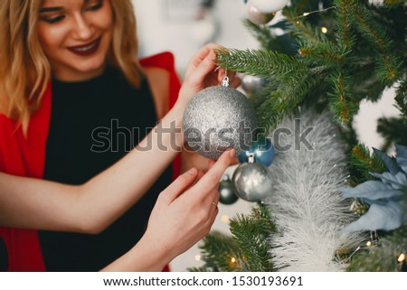In a beautiful decorated room with a Christmas tree is standing a two young girs