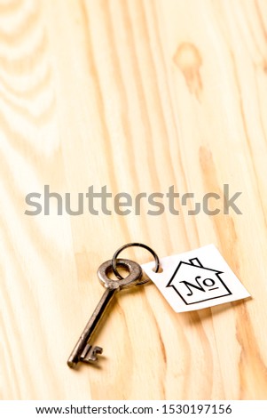 Home Concepts. Home or House Symbol Along With Old Silver Key With Number Mark Over Vintage Wooden Background.Vertical Shot