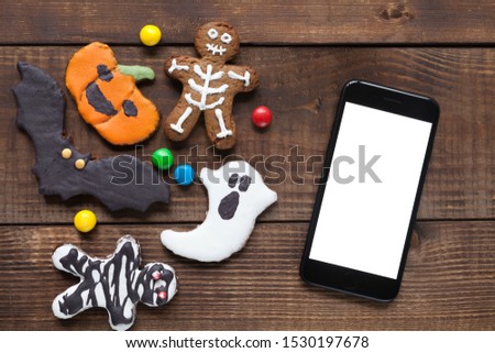 Halloween cookies on wood desk: ghost, pumpkin, bat, mummy, skeleton