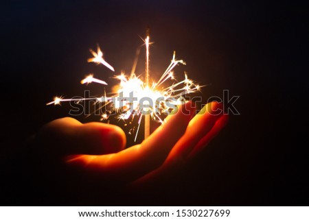 Hand Holding Bright Burning SParkler Celebrating The Festive Season, Joy And Cheerful Concept, Holidays And Festivities, 4th Of July And Christmas  And New Year Background