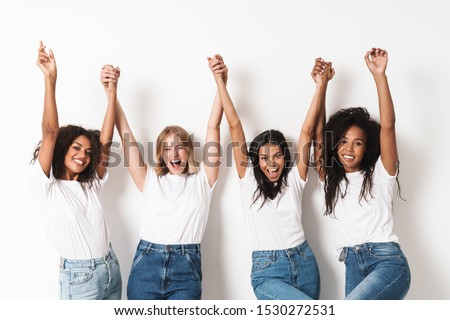 Image of a pretty happy young women multiracial friends posing isolated over white wall background with raised hands.