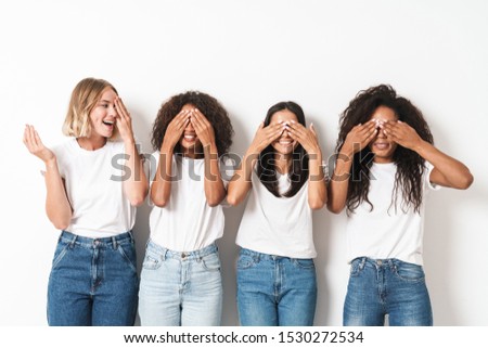 Photo of a pretty positive young women multiracial friends posing isolated over white wall background covering eyes.