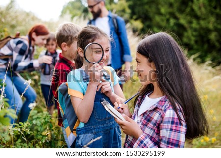 Group of school children with teacher on field trip in nature, learning science. Royalty-Free Stock Photo #1530295199