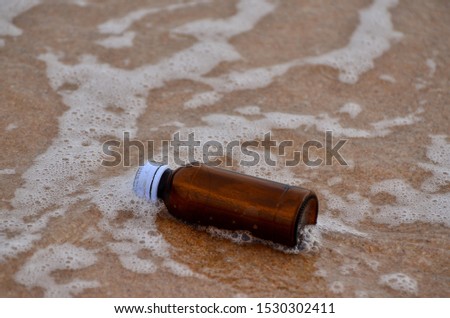 Glass bottles on the beach, environmental pollution concept picture. Hazardous waste on the beach.