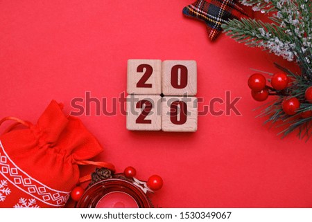 Christmas and new year 2020 concept, wooden cubes and decorations on red background