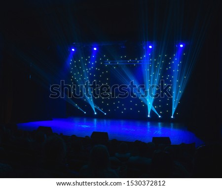 Classic blue light beams spotlights on dark background. Colorful beautiful spotlight on stage in dark at time of entertainment show. Concept of music festival, laser and lights show.