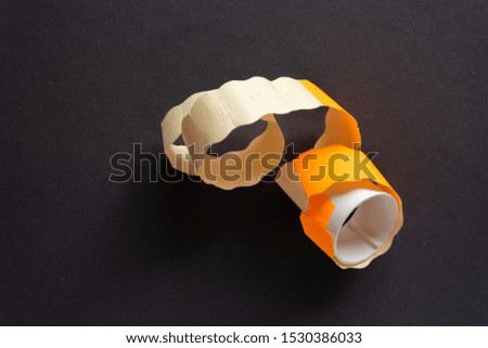 Price tags and stickers orange in a roll on a dark gray background of paper.