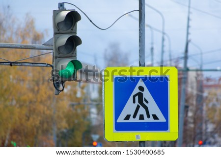 Old traffic light with green signal and road sign pedestrian crossing in Russia