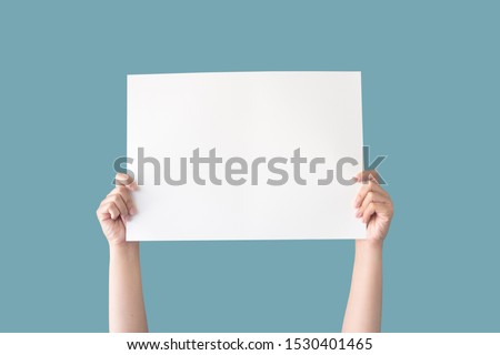 hand holding white blank paper isolated on blue background with clipping path Royalty-Free Stock Photo #1530401465