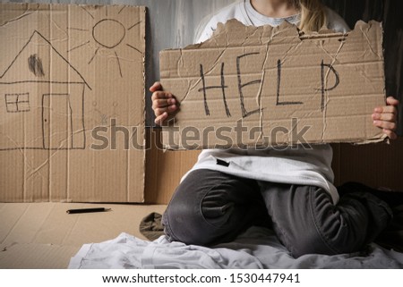 Homeless little girl begging for help near wall