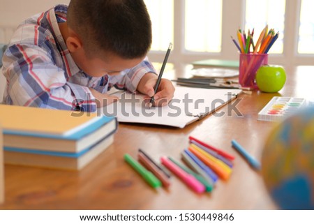 little asian kid boy child schoolboy drawing picture. children leisure activity at home