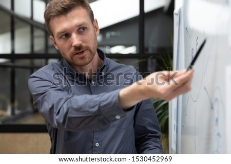 Coach or mentor makes presentation for staff showing on flip chart data informative visual content provide useful information at business training, corporate team building activity, workshop concept