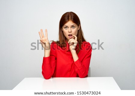 Emotional Business woman desktop red shirt gesturing with fingers