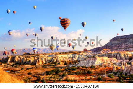 Flying on the balloons early morning in Cappadocia. Colorful sunrise in Red Rose valley, Goreme village location, Turkey, Asia. Traveling concept background.