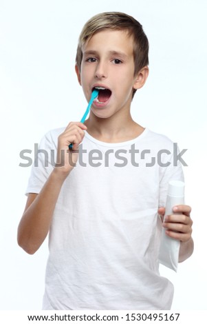 kid smiles while brushing his teeth