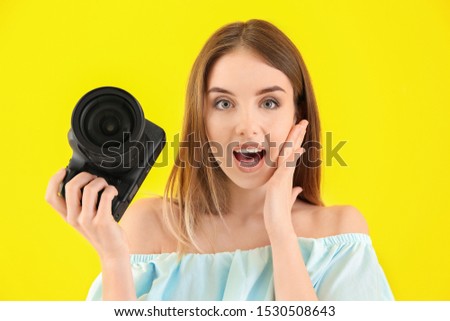 Confused female photographer on color background