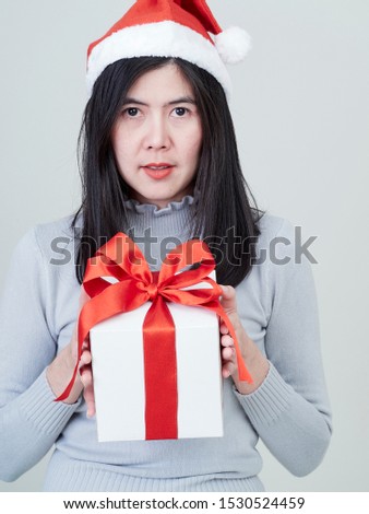 Christmas Concept. Young beautiful woman in santa hat with gift box in hand on white background