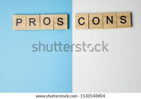 "Pros and Cons" word in the wooden block on duo color background Royalty-Free Stock Photo #1530548804